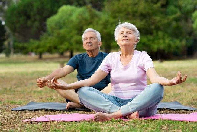 Deux personnes âgées méditant ensemble, mettant en évidence l'importance de la méditation pour la prévention de la démence et le maintien de la santé cognitive.