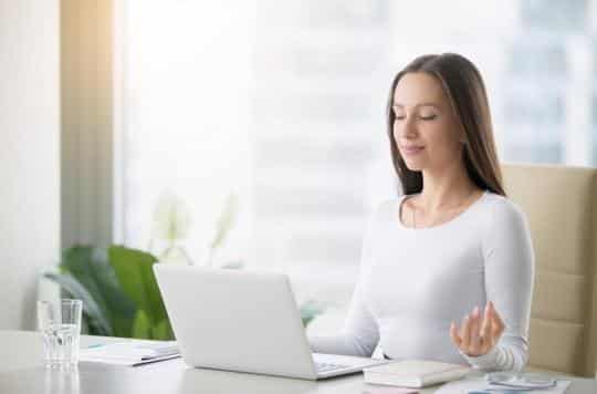 Une femme pratiquant la méditation, symbolisant comment celle-ci aide à réduire les erreurs du cerveau.