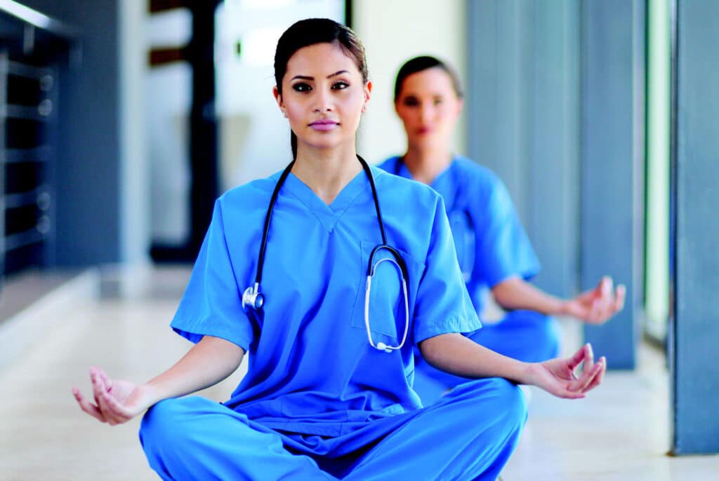 Deux infirmières pratiquant la méditation de pleine conscience, mettant en évidence l'utilisation de cette pratique bénéfique dans le cadre professionnel des soins infirmiers.