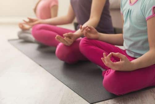 Une image illustrant des écoliers pratiquant la méditation, mettant en évidence les bienfaits de cette pratique pour la gestion du stress chez les élèves.