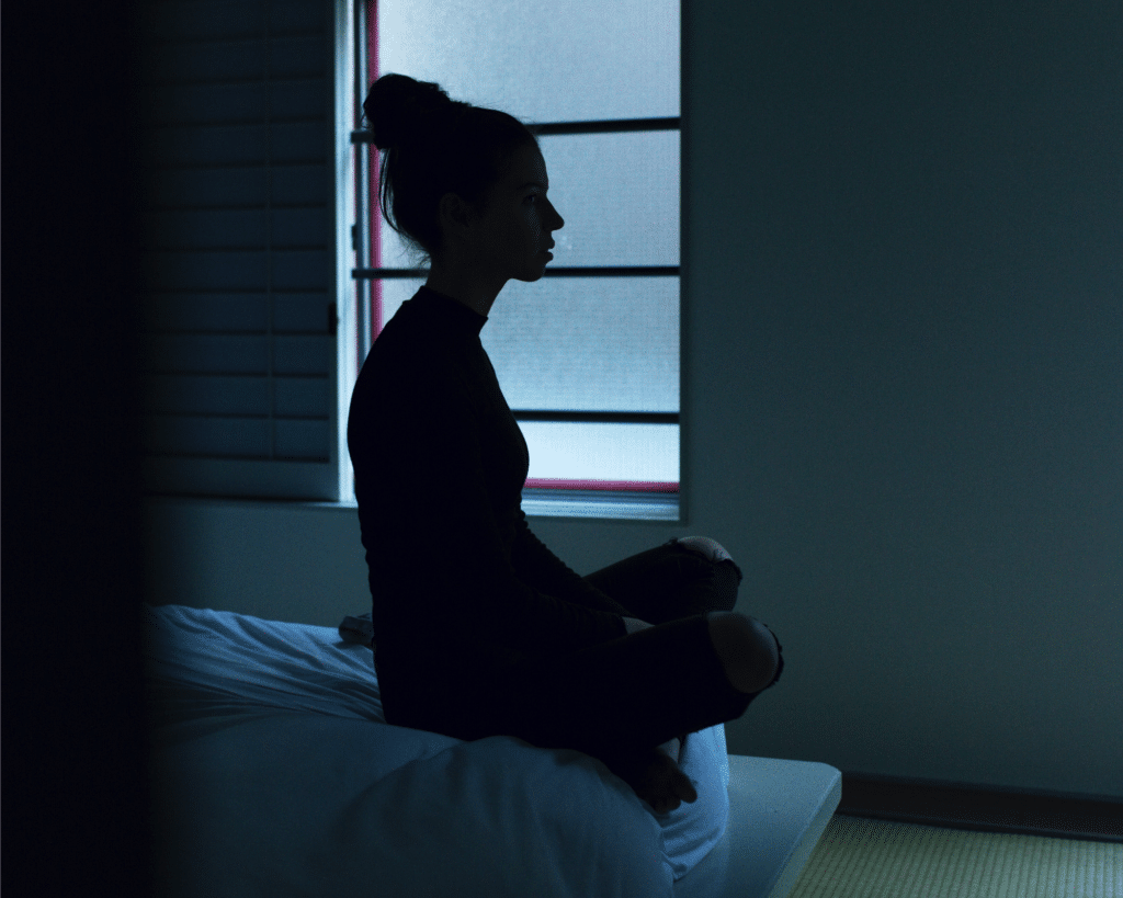 jeune femme pratiquant la meditation contre la dépression sur son lit