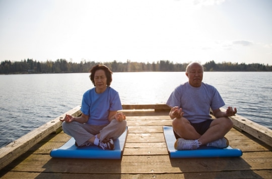 Une personne âgée utilise la méditation comme outil de relaxation et de maintien d'un esprit sain face au vieillissement.