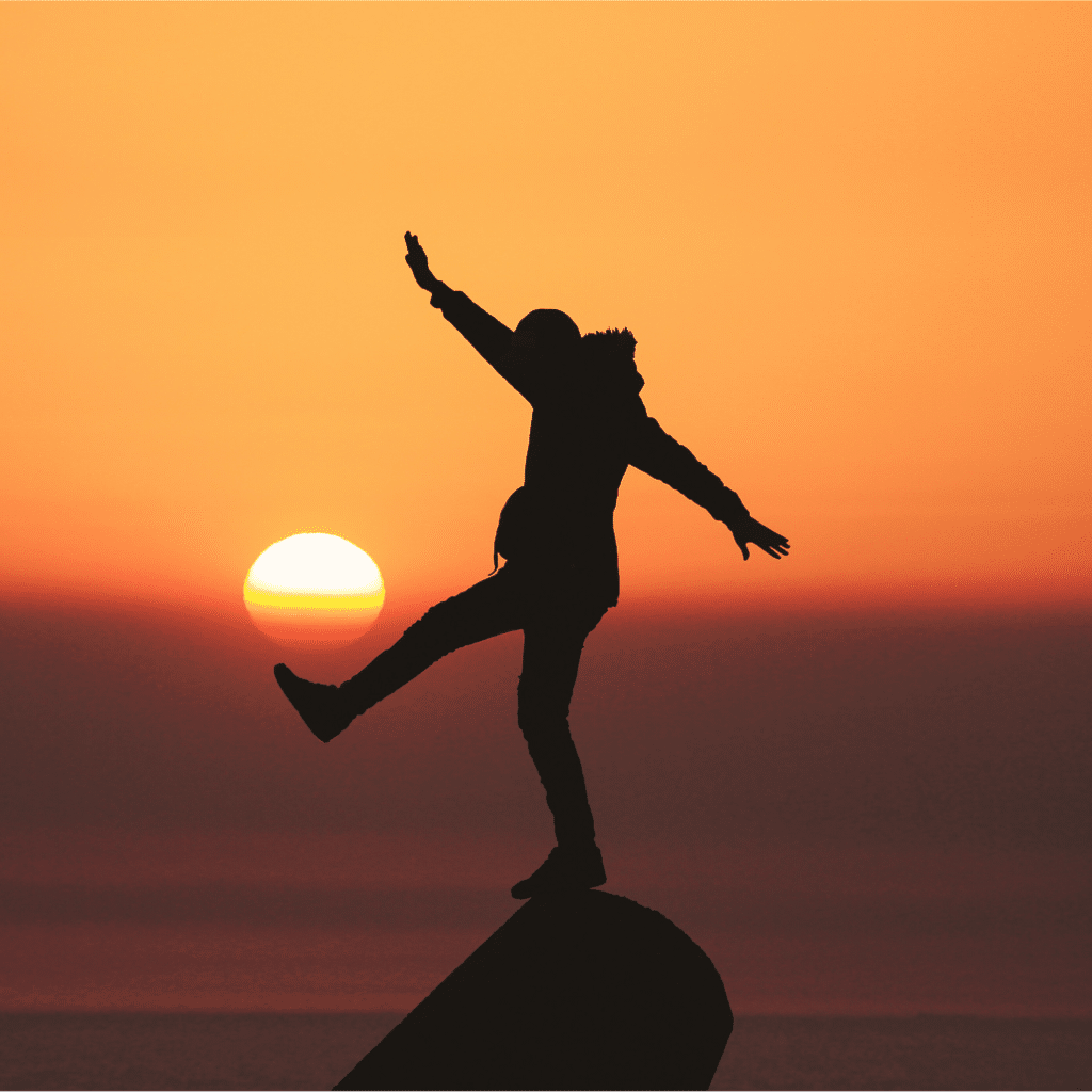 homme en équilibre sur un rocher au coucher du soleil les bienfais de la meditation en pratique