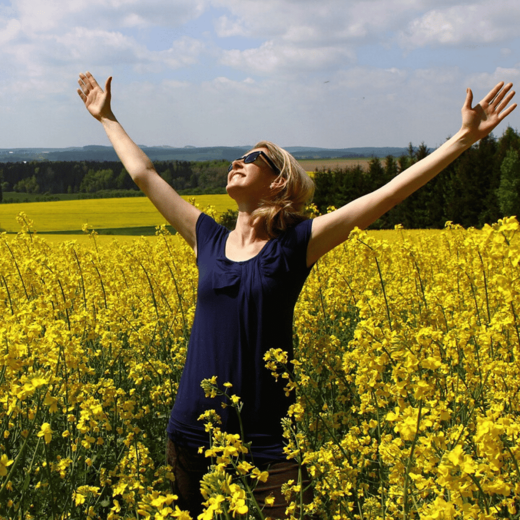 femme Contente et reconnaissante dans un champ de fleurs