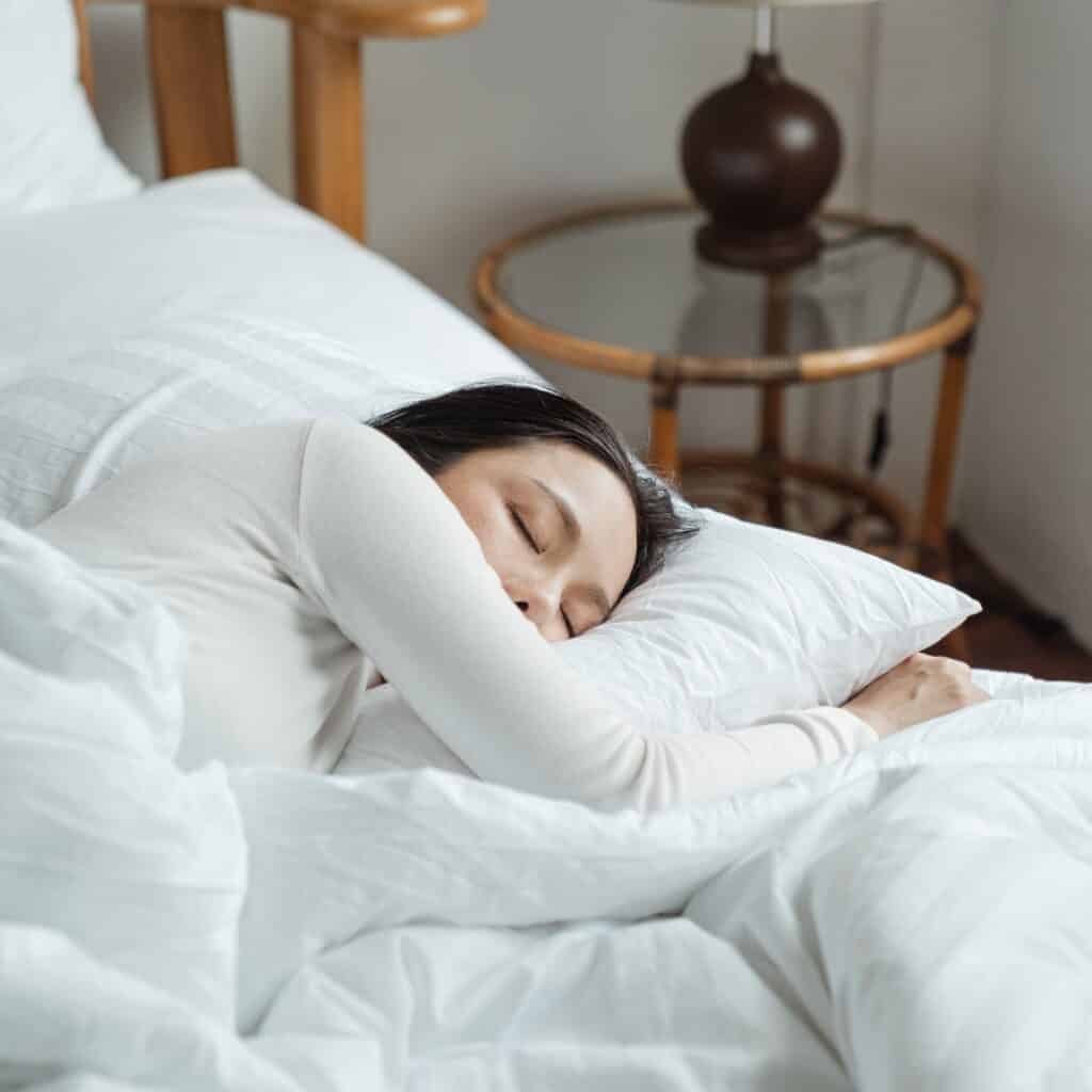 femme qui dort paisiblement et qui a amelioré son sommeil par la meditation