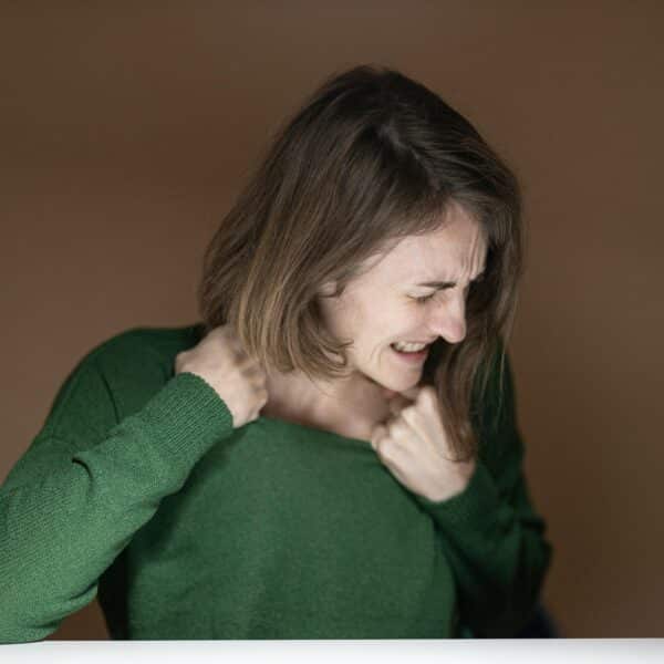 femme qui souffre du cou et pourrait pratiquer la meditation de pleine conscience