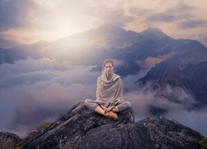 femme qui médite au sommet d'une montagne pour faire baisser sa tension arterielle