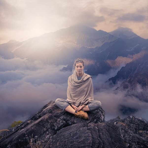 femme qui médite au sommet d'une montagne pour faire baisser sa tension arterielle